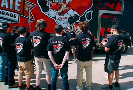 The Immediate Movers crew gathers in front of a branded truck before a move.