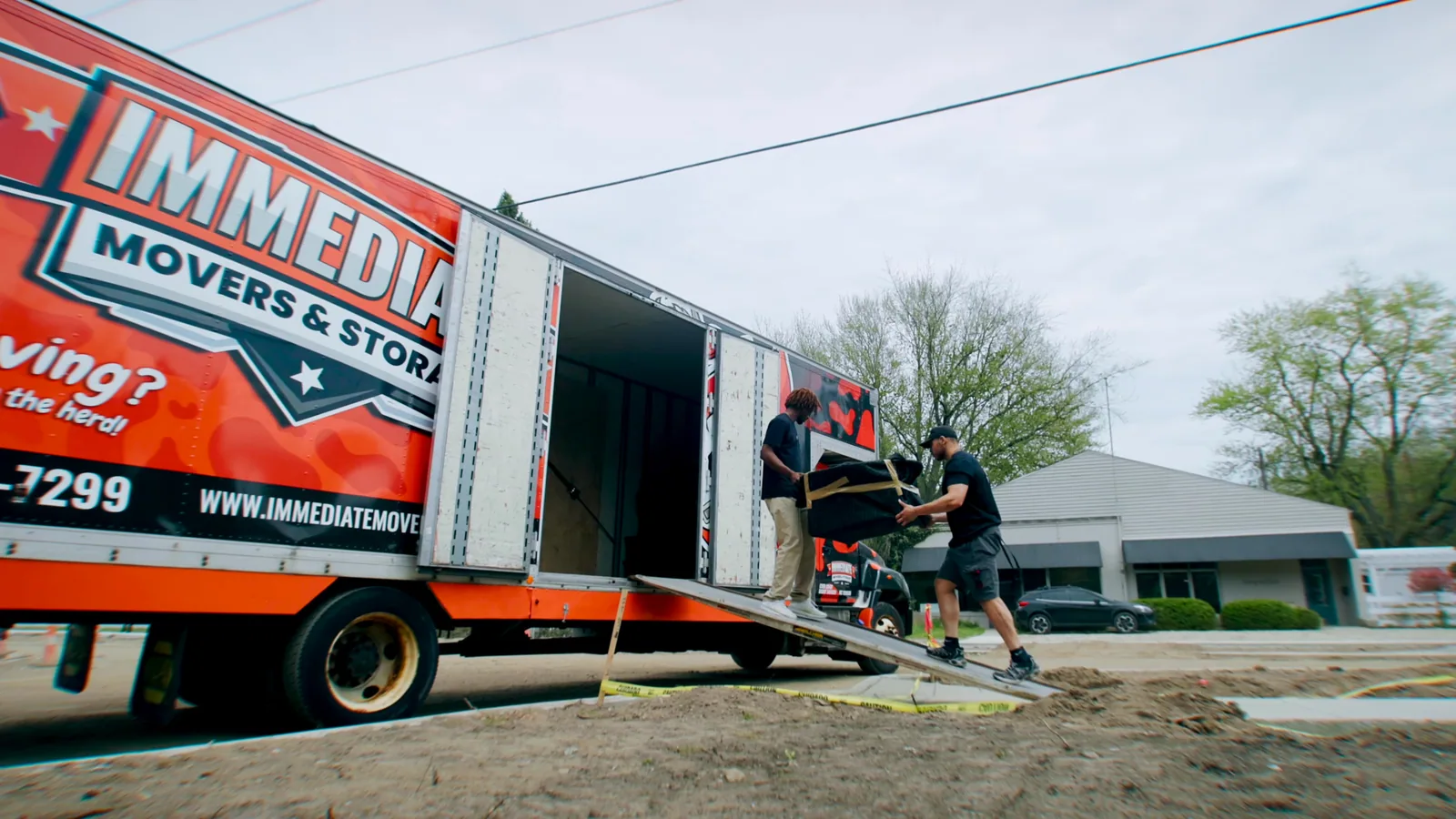 The crew unloads an Immediate Movers truck in the driveway of a customer's home.