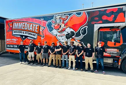 The Immediate Movers & Storage team lined up beside a branded moving truck.